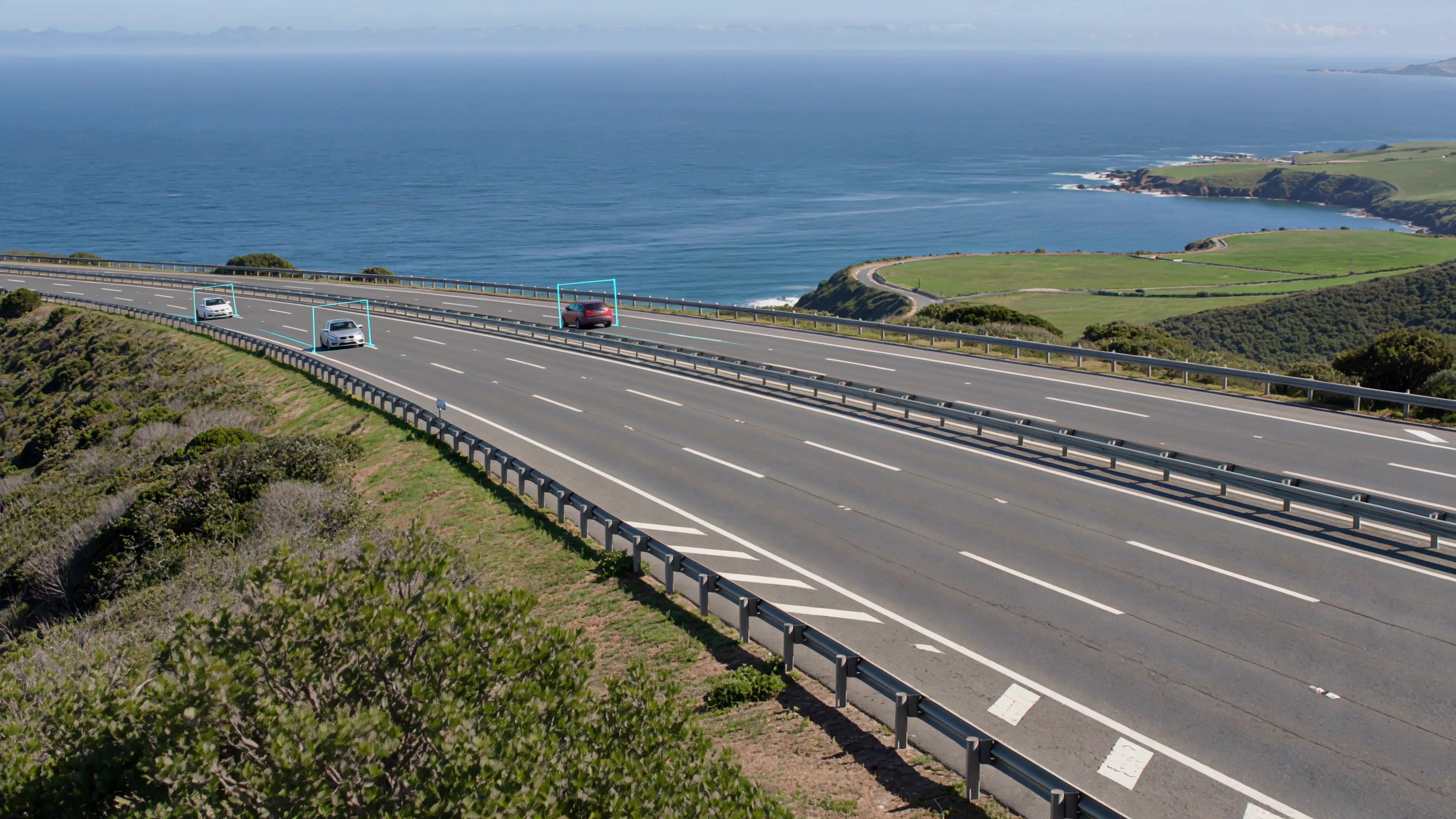 Cars on a coastal highway with illustrative computer-vision tracking overlays